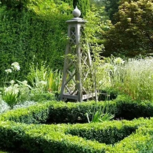 Painted timber obelisk with pointed finial in a knot garden with box hedging